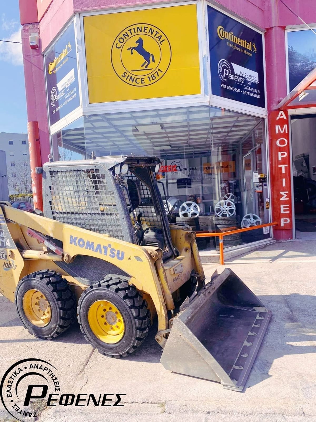 Κίτρινο φορτωτή Komatsu με χοντρά ελαστικά, μπροστά στο κατάστημα